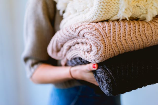 Bulky sweaters held by woman
