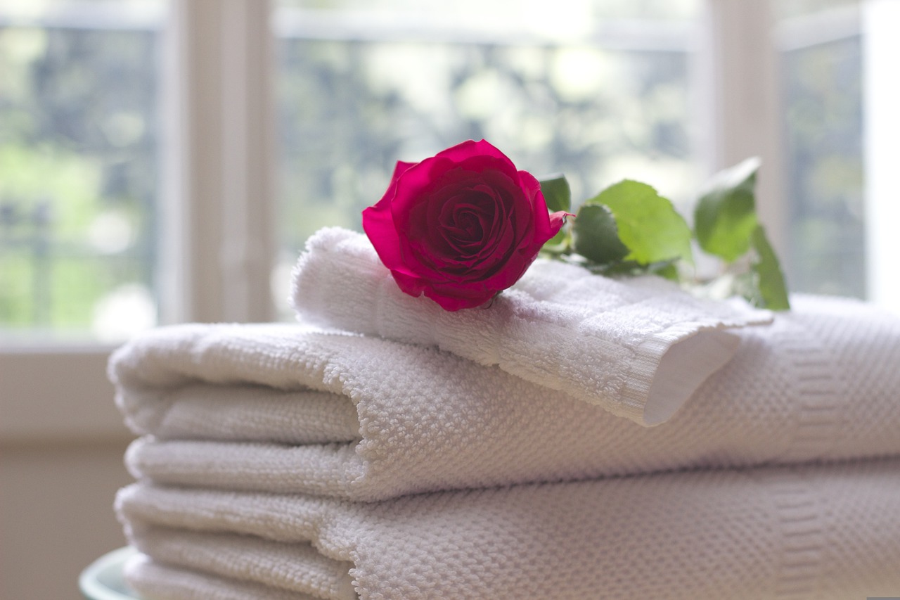 Stack of towels with rose on top