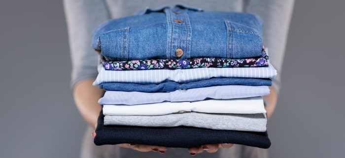 woman-holding stack of folded laundry